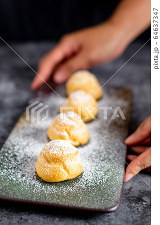 Eclair, choux filled vanilla custard cream and dusted with icing, dessert on a plate with copy space 64637347