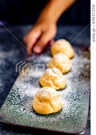 Eclair, choux filled vanilla custard cream and dusted with icing, dessert on a plate with copy space 64637350