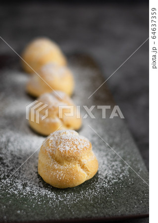 Eclair, choux filled vanilla custard cream and dusted with icing, dessert on a plate with copy space 64637359