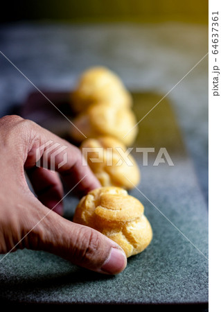 Eclair, choux filled vanilla custard cream and dusted with icing, dessert on a plate with copy space 64637361