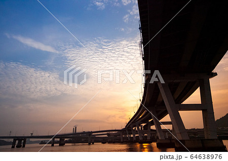 海に架かる大橋の夕焼けの景色です。空の色合いや流れ雲の様子がきれいです。テキスト背景にどうぞ。 海に架かる大橋の夕焼けの景色です。空の色合いや流れ雲の様子がきれいです。テキスト背景にどうぞ。 64638976