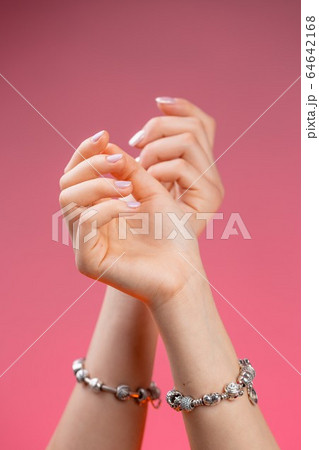 Closeup of woman's hands on pink background Closeup of woman's hands on pink background 64642168
