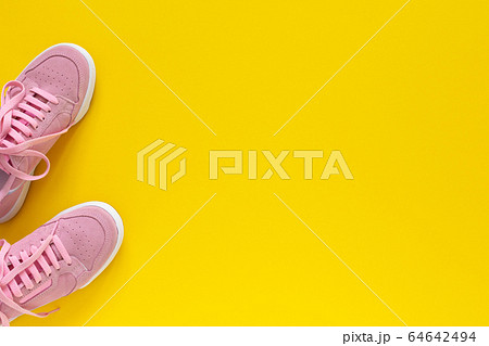 Pink sneakers isolated on a yellow background Pink sneakers isolated on a yellow background 64642494