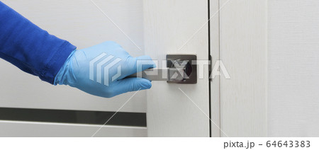 Mens hand in a blue protective gloves opens or close the door. Antibacterial prophylaxis banner in times of viruses and infections. Health and protection concept 64643383