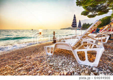 Sun loungers and beach umbrellas at sunset on the 64644900
