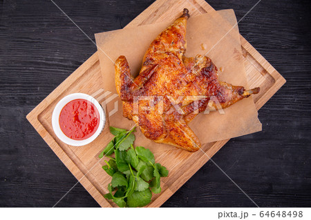 Chicken tobacco fried on coal with garlic, served with greens and ketchup Chicken tobacco fried on coal with garlic, served with greens and ketchup 64648498