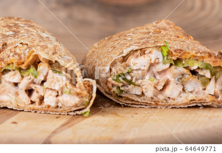 Shawarma Middle Eastern dish of pita bread, stuffed with grilled and then minced chicken meat. Shawarma Middle Eastern dish of pita bread, stuffed with grilled and then minced chicken meat. 64649771