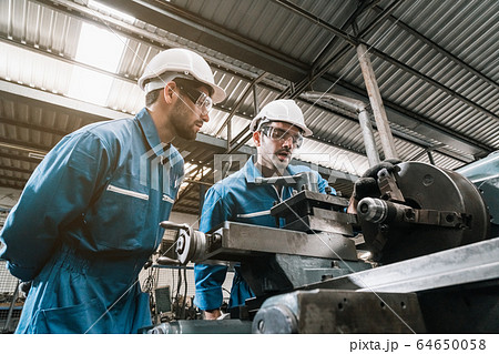 Engineer men wearing uniform safety in factory working machine lathe metal. 64650058
