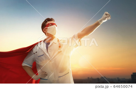 Doctor wearing facemask and superhero cape 64650074