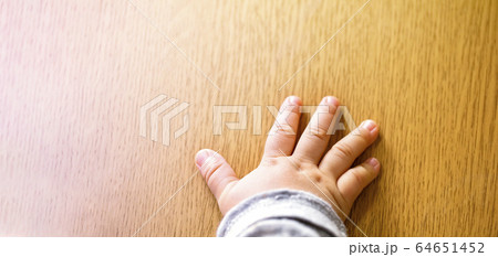 赤ちゃんの愛らしいぷっくりした手とコピースペースと木目バック 64651452