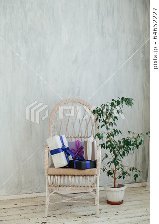 white chair with gifts and home plants in the interior of the room 64652227