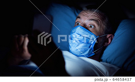 Scared Mature Guy Using Smartphone In Bed Indoors At Night 64658437