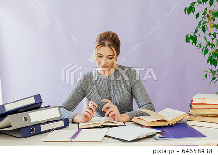 business woman working at a desk in the office with books training business woman working at a desk in the office with books training 64658438