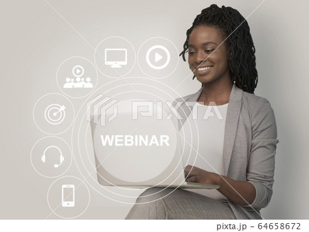 African American woman watching online webinar on laptop, collage with remote learning pictograms on screen 64658672