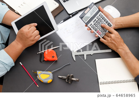The engineering team is working on their project together. 64658965