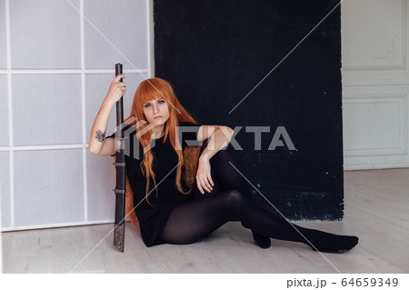 red-haired girl with a Japanese sword cosplayer anime Japan red-haired girl with a Japanese sword cosplayer anime Japan 64659349