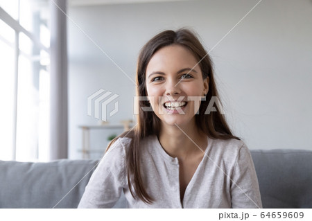Smiling teen girl talking by video call looking at camera 64659609