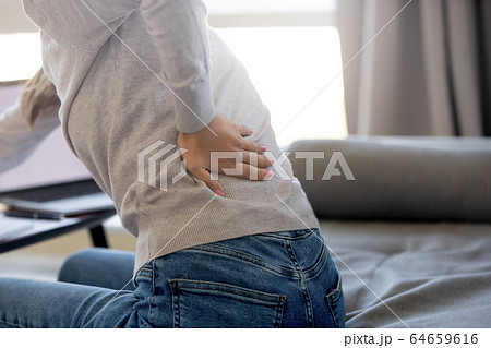 Rear closeup view at woman touching aching back feeling pain Rear closeup view at woman touching aching back feeling pain 64659616