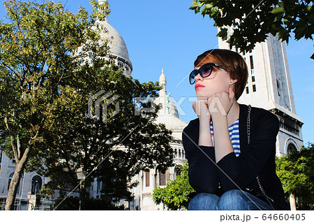 Young woman near Basilica of the Sacred Heart of Paris, France. 64660405