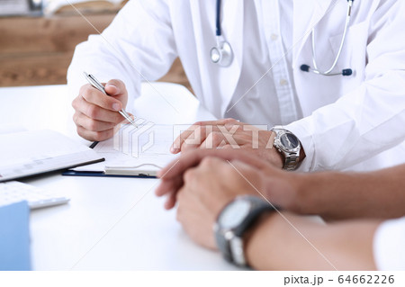 Concerned handsome doctor communicate with patient Concerned handsome doctor communicate with patient 64662226