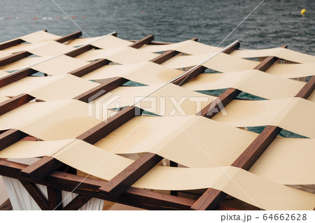 Unusual roof closure. The roof of the restaurant on the street by the sea. Fabric roof Unusual roof closure. The roof of the restaurant on the street by the sea. Fabric roof 64662628