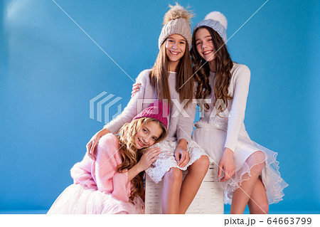 Three beautiful fashionable girls in winter cap snow 64663799