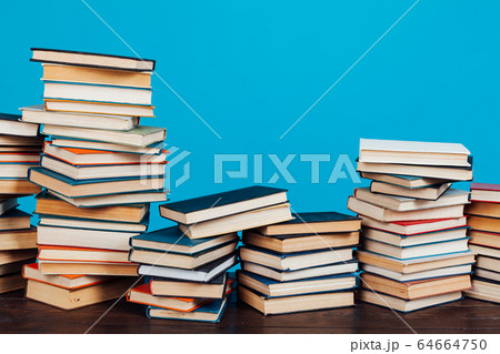many stacks of educational books for learning preparation for college exams on a blue background 64664750