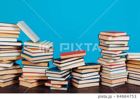 many stacks of educational books for learning preparation for college exams on a blue background 64664753