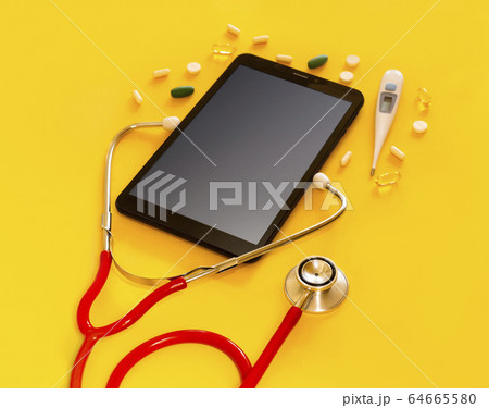 Red stethoscope and a tablet PC with a medical app, copyspace Isolated yellow background. Concept telemedicine, mock up, top view, pills, medication, thermometer, doctor online 64665580