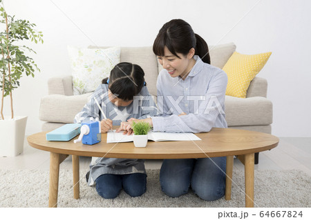 自宅で子供に勉強を教える母親 64667824