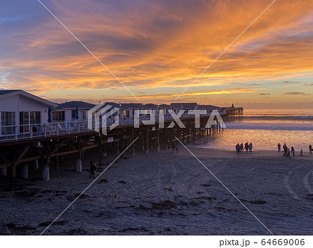 Pacific beach shoreline and pier during colorful sunset. Pacific beach shoreline and pier during colorful sunset. 64669006