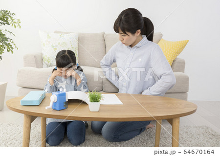 自宅で勉強中に子供を叱る母親 64670164
