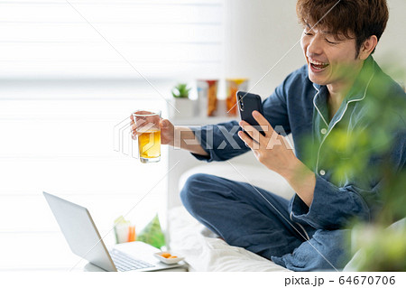 リモート オンライン ビデオ通話 飲み会 自宅 宅飲み 男性の写真素材