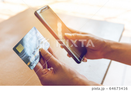 Woman holding credit card and smartphone. On-line Woman holding credit card and smartphone. On-line 64673416