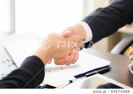Business people shaking hands, finishing up a meeting Business people shaking hands, finishing up a meeting 64674088