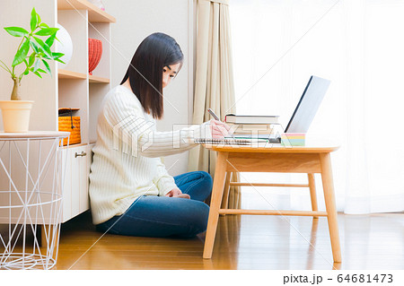 ノートに書き込む女性　PC　参考書　付箋　コピースペース 64681473