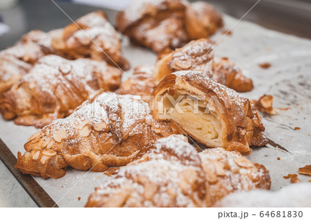 Croissants with almond flakes and icing sugar. 64681830