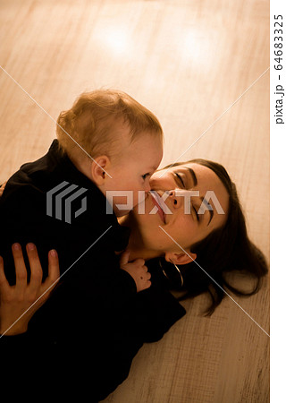 Cute cheerful child with mother play indoors. 64683325