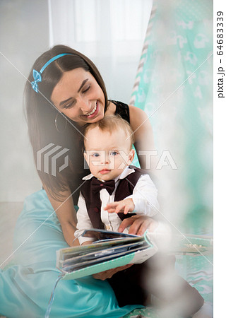Cute cheerful child with mother play indoors. 64683339
