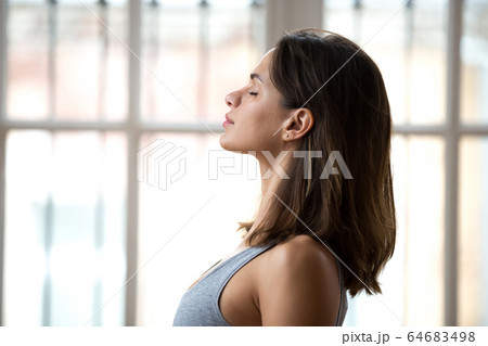 Attractive woman standing with closed eyes ready for yoga classe 64683498