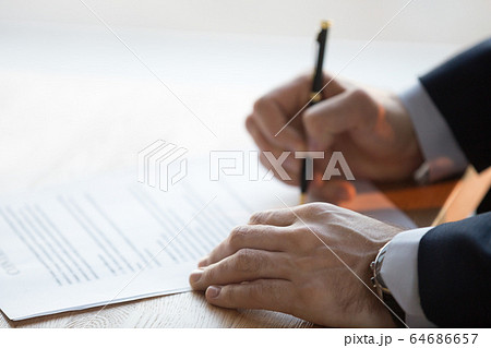 Close up view of male hand signing business contract concept Close up view of male hand signing business contract concept 64686657