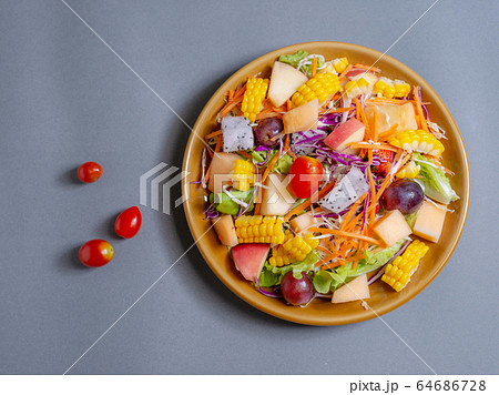 Fruits salad and vegetable in dish plate on gray Fruits salad and vegetable in dish plate on gray 64686728