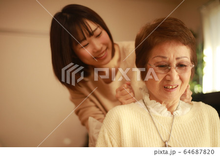 肩叩きする女性 64687820