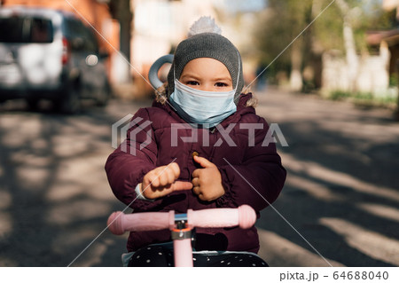Toddler child wearing face medical mask outdoors in cold weather. air pollution pm2.5 or covid-19 Toddler child wearing face medical mask outdoors in cold weather. air pollution pm2.5 or covid-19 64688040