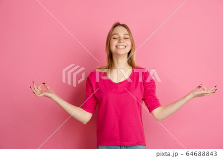 Caucasian young woman's monochrome portrait on pink studio background, emotinal and beautiful Caucasian young woman's monochrome portrait on pink studio background, emotinal and beautiful 64688843