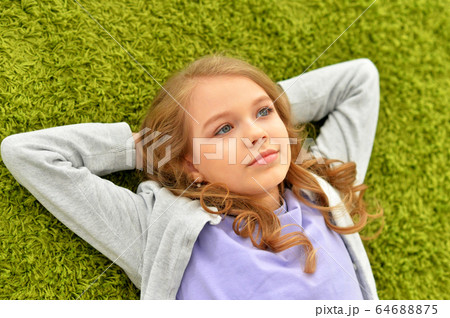 Portrait of beautiful teen girl lying on floor 64688875