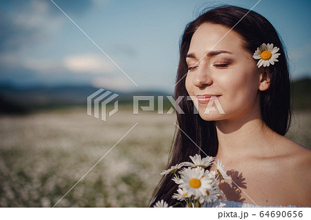Beautiful brunette woman is enjoying spring in a Beautiful brunette woman is enjoying spring in a 64690656