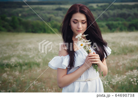 Beautiful brunette woman is enjoying spring in a Beautiful brunette woman is enjoying spring in a 64690738