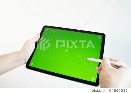 Hand draws a pencil on a tablet with a chromakey on the screen. 64693055