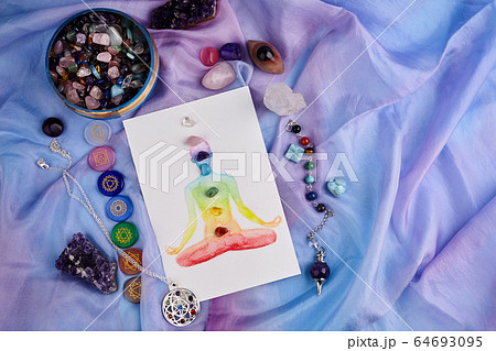 Natural crystals and pendulum on pastel silk background. Reiki background with card. 64693095